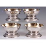 A SET OF FOUR GEORGE II SILVER SALTS the dish-shaped bodies with gilded interior on circular foot