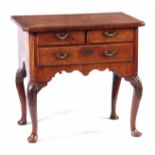 A GEORGE I WALNUT LOWBOY / SIDE TABLE with inverted corner and cross-banded top, above three drawers