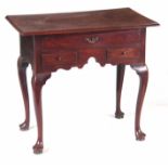 A GEORGE II MAHOGANY LOWBOY having a rectangular moulded edge top above three drawers with shaped