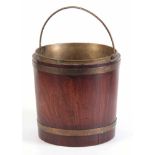 AN 18TH CENTURY BRASS BOUND FIGURED MAHOGANY OYSTER PALE BUCKET with brass liner and folding