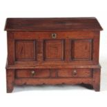 AN EARLY 18TH CENTURY WELSH OAK COFFER BACH with drop in moulded plank top, having a triple