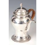 AN EDWARDIAN SILVER ARGYLE having a domed hinged lid with twisted finial above a waisted baluster