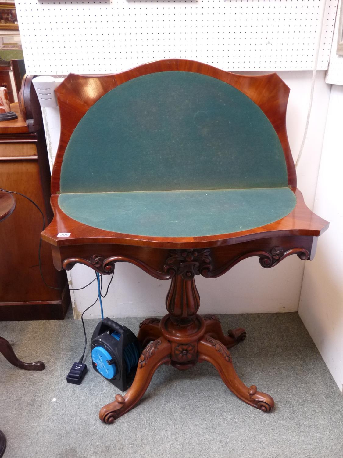 19thC Mahogany fold over card table with inlaid baize, Highly carved support over floral carved