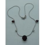 Ladies 18ct White Gold Necklace of 3 Oval Claw set Almandine garnets and 2 Claw set Diamonds 0.