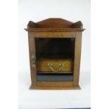 Oak Edwardian Smokers cabinet of glazed front and single drawer with brass drop handle