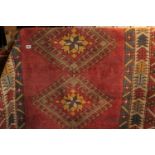 Red Ground Rug of Geometric design with tassel ends