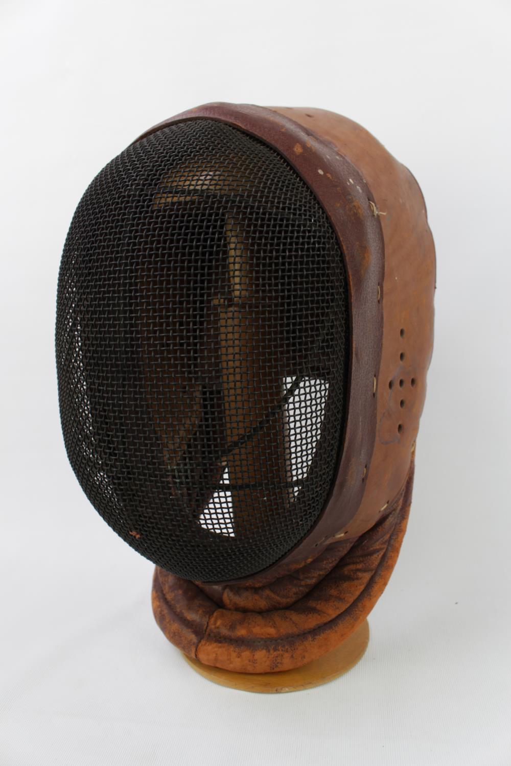 Mid 20thC Leather fencing mask with Mesh front stamped BLG Ltd dated 1949 on walnut stand