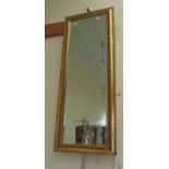 A long bevelled gilt wall mirror