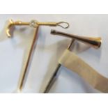 A yellow metal stick pin riding crop set small diamond and another hunting horn
