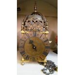 A brass lantern clock with pendulum and weight
