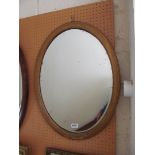 An oval gilt framed bevelled mirror