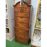 A walnut tallboy with swan neck pediment, two short and three long drawers above, slide and three