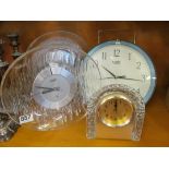 Three glass framed clocks and a modern wall clock