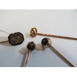 A Victorian stick pin inset hair in black enamel mount and three other Victorian stick pins