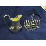 A silver jug and toastrack.