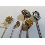 A Victorian stick pin set enamel star design and seed pearl and four other stick pins