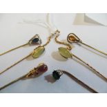 A double stick pin set citrine with chain link and four other gem set stick pins