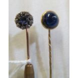 A sapphire and diamond cluster stick pin and another set cabouchon blue stone