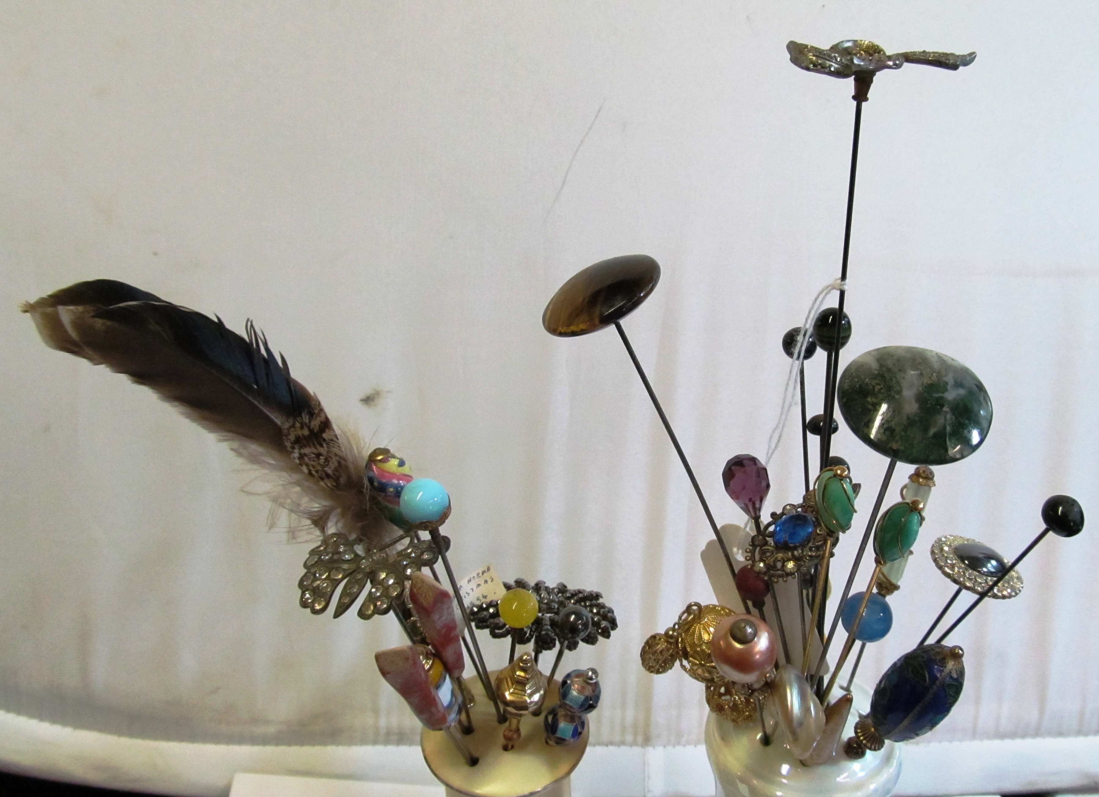Various decorative hat pins in two hat pin holders