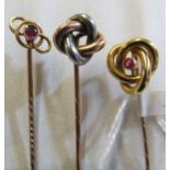 An 18ct gold stick pin with ruby and knot terminal and two others in the form of knots