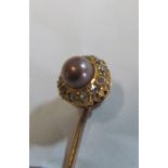 A yellow metal stick pin with diamond and coloured pearl cluster