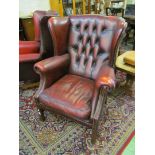 A reproduction leather upholstered wing style armchair