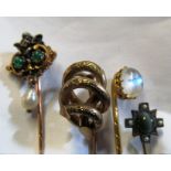 A Victorian stick pin with cherub set emerald and pearl drop and three other stick pins