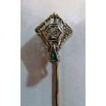 An Art Deco stick pin set diamond and triangular shaped emerald (i.c.)