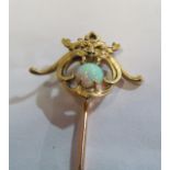 A Victorian yellow metal stick pin with mask head holding an opal (i.c.) STONE CHIPPED