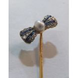 An Art Deco stick pin with bow set seed pearl, sapphires and diamonds (i.c.)