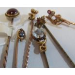 A yellow metal and garnet stick pin and five other Victorian stick pins