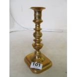A brass candlestick with pusher