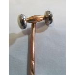 A white and yellow metal stick pin in the form of a gavel (i.c.)