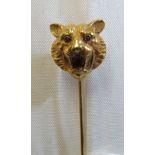 A yellow metal stick pin tigers' head set ruby stone