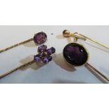 A yellow metal cameo in amethyst with intaglio carving crest and three other stick pins inset