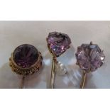 An amethyst and seed pearl heart shaped stick pin, another circular and another set purple stone