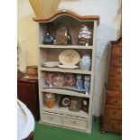 A painted green bookshelf with dome top and two drawers under.