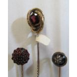 A Victorian stick pin set garnet cluster, another with garnet in knot and another cabouchon with
