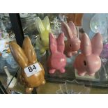 A brown Wade Heath rabbit and three pink and yellow rabbits