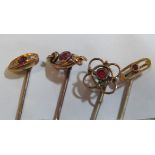 A 15ct gold stick pin set ruby and three other stick pins set red stones