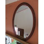 An oval mahogany mirror