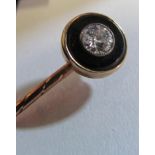 A yellow metal black onyx and diamond stick pin