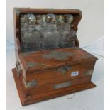 An oak Tantalus with three bottles, two lift up flaps and secret drawer