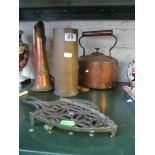 A brass and copper bugle, copper kettle, shell case and two trivets