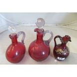 Two Cranberry glass decanters ( 1 repaired) and a frilled edge jug