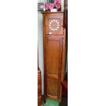 An oak cased battery operated longcase clock the single door opening to reveal bookshelves