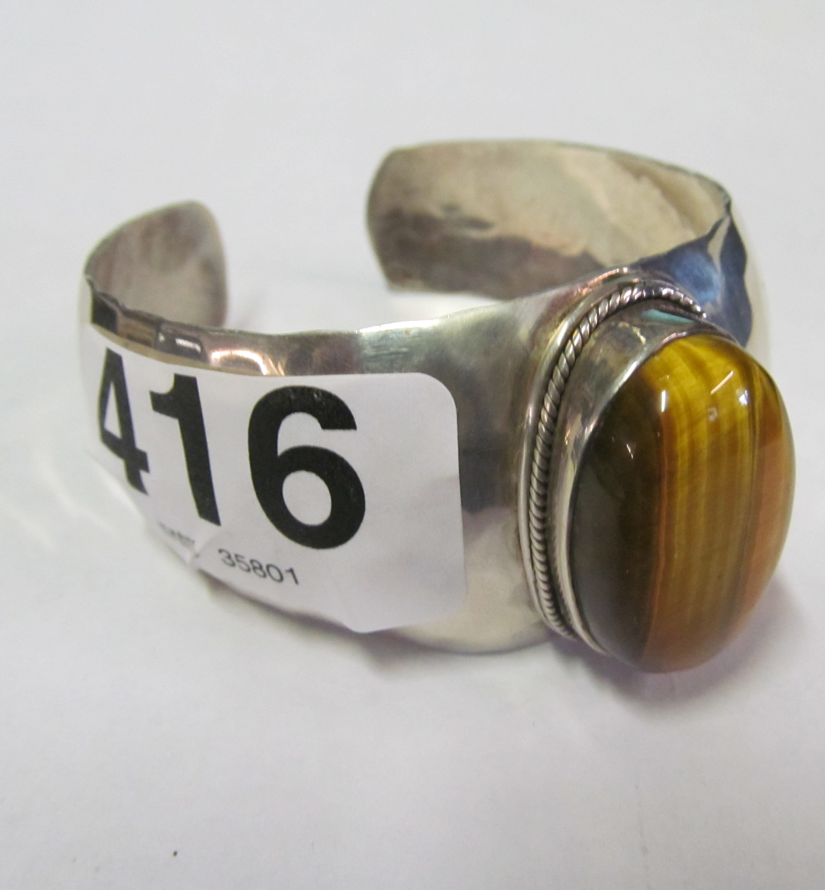 A beaten silver and tigers eye bangle bracelet