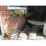 A small circular garden table and four folding chairs