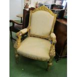 A pair of ornate gilt French style armchairs carved floral detail with classical arms upholstered in