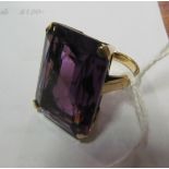 An 18ct gold dress ring set large purple stone